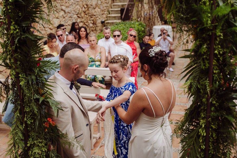 The bride and groom share a moment with a young guest during the ceremony